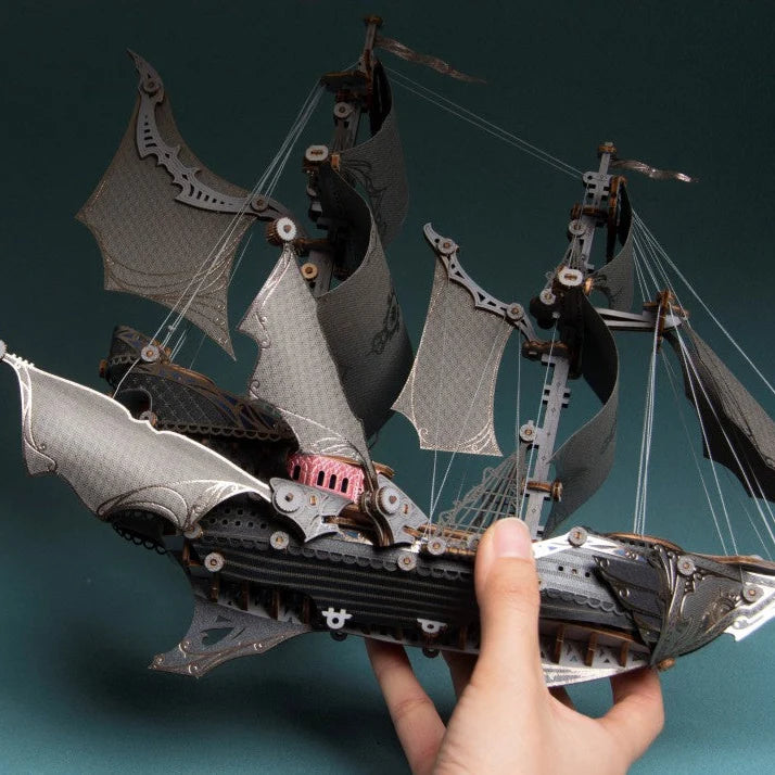 Hands holding the Black Fantasy Elfship 3D wooden ship model with intricate rigging and sails